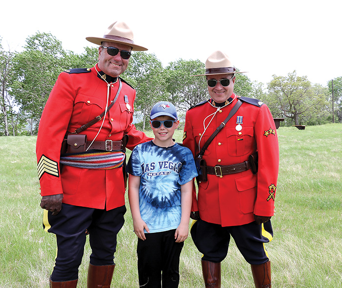 S/Sgt. Matt Lavallee and Corporal Brett Church of Prairie Mountain RCMP with a local student at the celebration of the site. <br />
